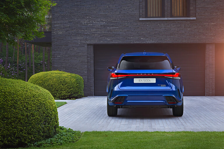 Voiture hybride Lexus RX garée devant un garage de maison