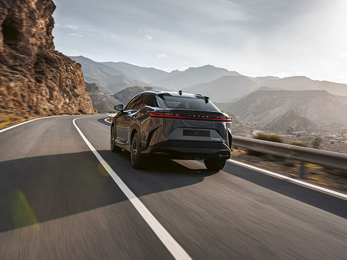 Arriere Voiture électrique Lexus RZ qui roule dans les montagnes