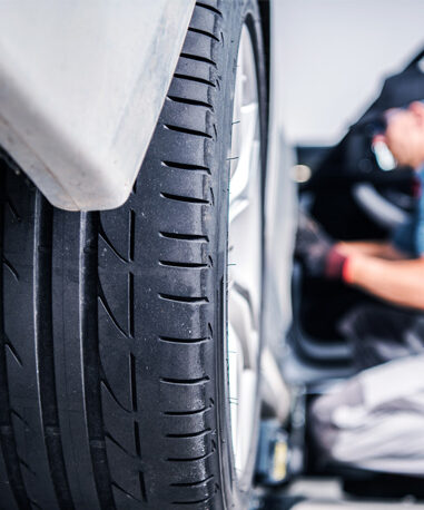 Techniciens voiture Lexus avec pneu en gros plan