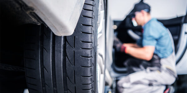 Techniciens voiture Lexus avec pneu en gros plan
