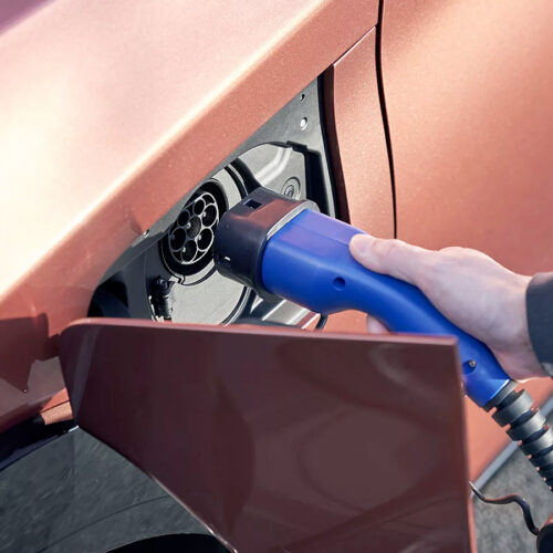 Main qui tient le cable de chargement d'une Lexus électrique