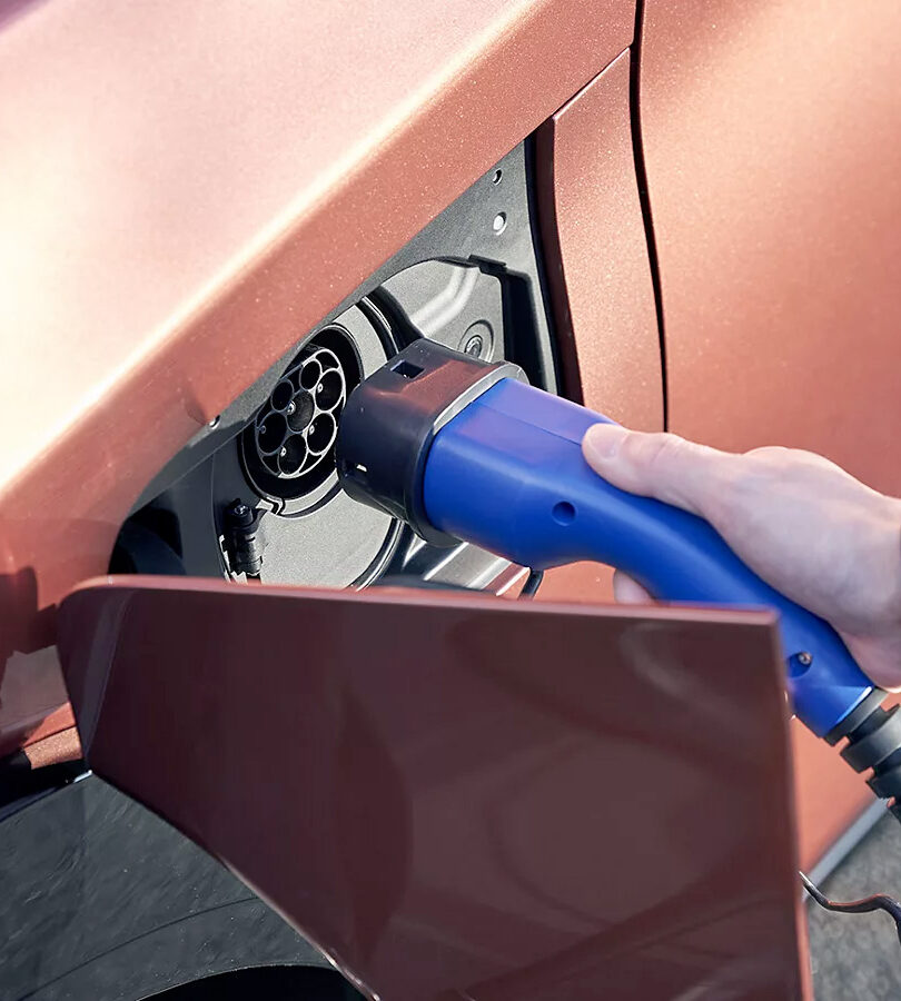 Main qui tient le cable de chargement d'une Lexus électrique