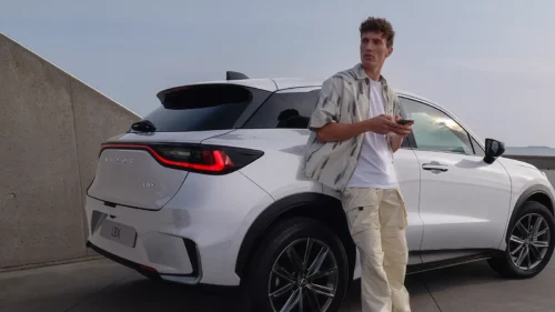 Homme debout à côté d'une Lexus tenant un télépone