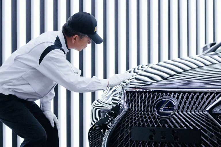 Artisan Takumi devant le capot d'une Lexus