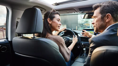Le vendeur et une cliente, le vendeur montre l'intérieur de la voiture