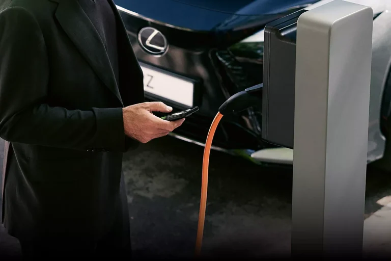 Homme devant une borne de recharge pour Lexus électrique